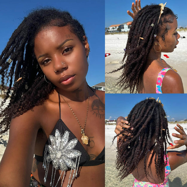 Woman on beach with curly human hair dreadlocks, adorned with shells and beads.